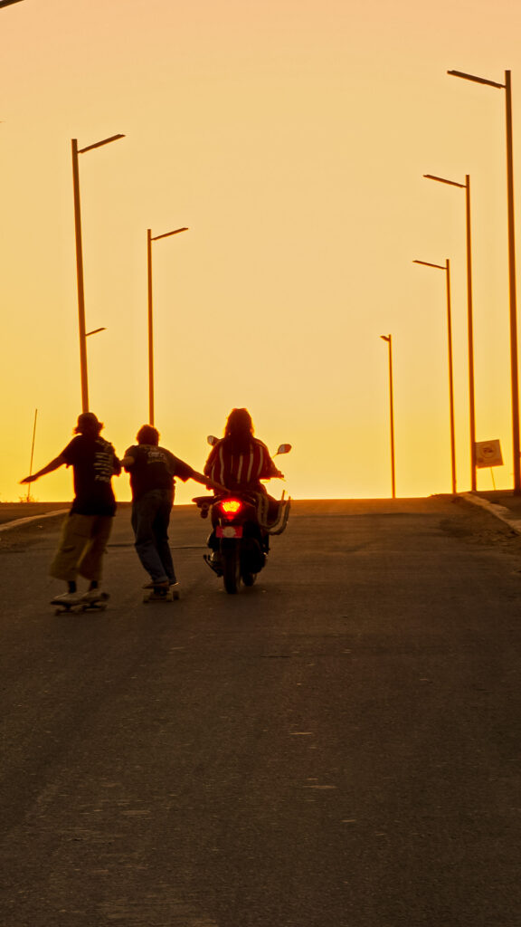 Customer driving into the sunset with two friends skating